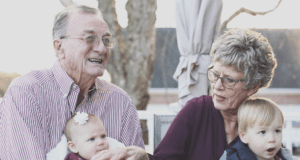 An elderly couple sitting with grandchildren.