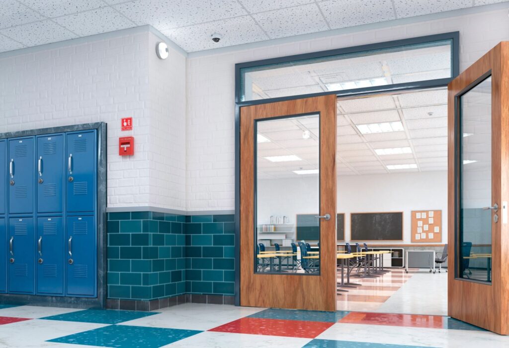School hallway with lockers and classroom showing emergency response infrastructure and panic button placement areas.